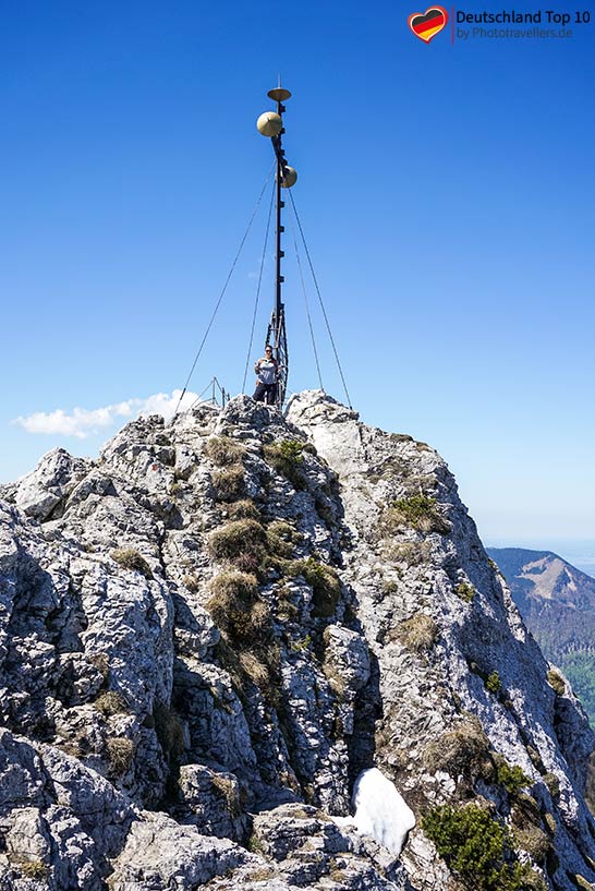 Reisebloggerin Biggi Bauer am Gipfel der Kampenwand mit dem großen Gipfelkreuz